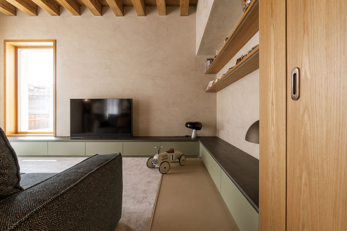 Zona giorno con pareti in cemento architettonico e pavimento continuo