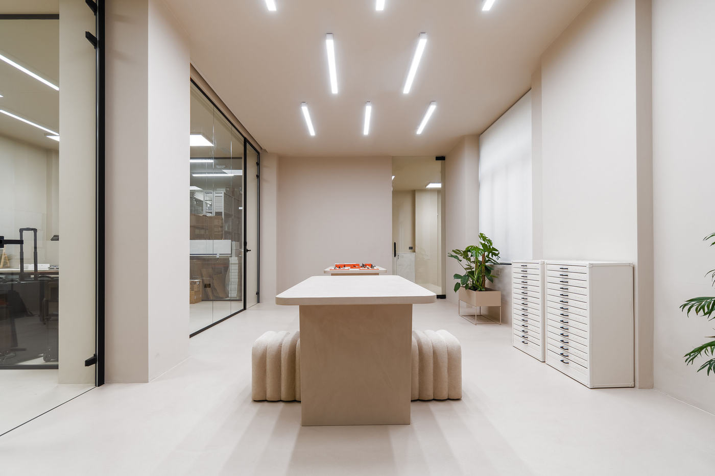 Showroom con pavimento continuo e tavolo monolitico nello stesso materiale